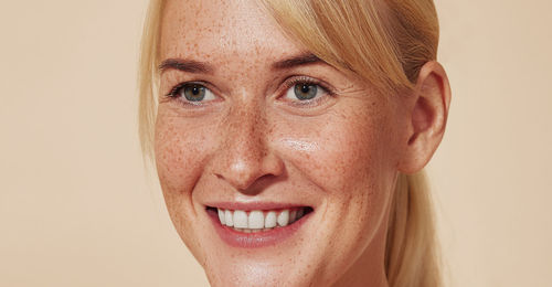 Close-up of young woman against pink background