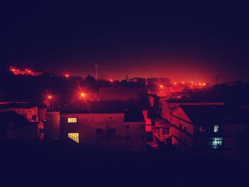 High angle view of illuminated buildings against sky at night