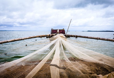 Scenic view of fishing boat in beach against sky