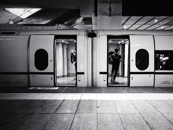 Rear view of man standing on tiled floor in city