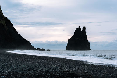 Scenic view of cliff by sea against sky