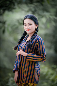 Portrait of young woman standing outdoors