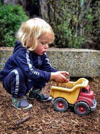 Cute boy playing with toy car