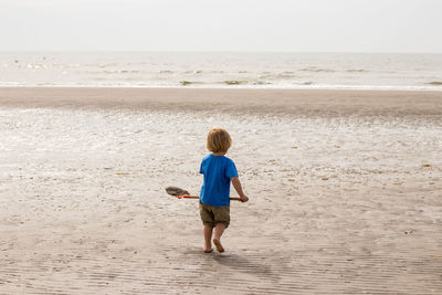 Rear view of boy on beach