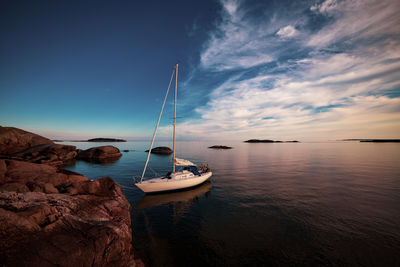 Sailboats in sea against sky during sunset