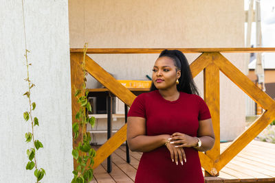 Portrait of young woman sitting on railing