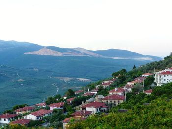 Town by mountains against clear sky
