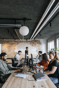 Male and female business entrepreneurs working at desk while sitting in start up office