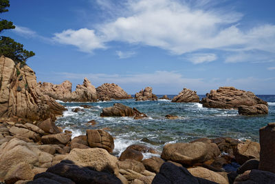 Rocks at beach against sky