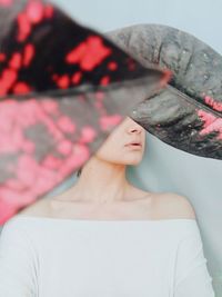 Woman covering face with leaves