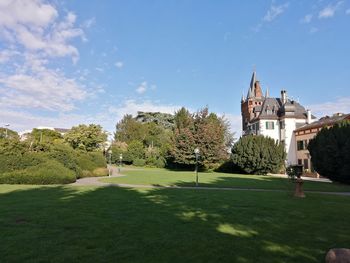 Lawn by building against sky