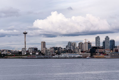 Buildings in city against cloudy sky