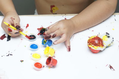 High angle view of hand holding painting on table