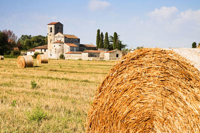 Hay bales on field against sky