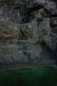 Low angle view of woman sitting on rock formation