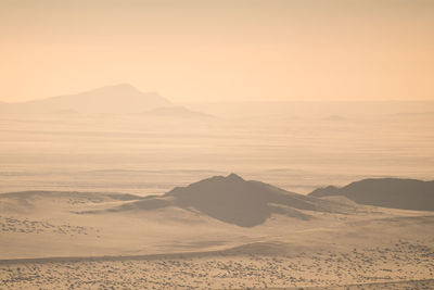 Scenic view of desert against sky during sunset