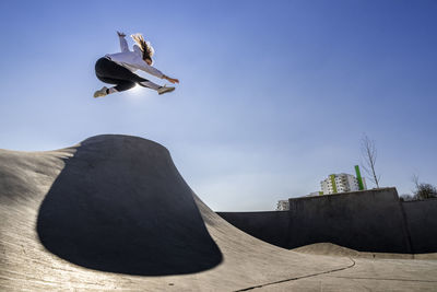 Young woman jumping at pump track on sunny day