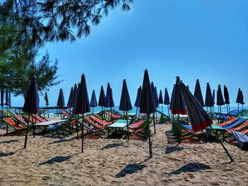 Panoramic view of chairs on beach against clear blue sky