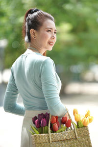 Midsection of woman with red chili peppers in basket