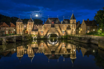 Reflection of buildings in lake at night