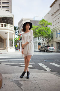 Portrait of young woman standing in city