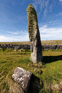 Stone structure on field against sky