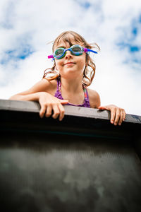 Low angle view of young woman wearing sunglasses against sky