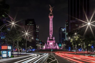 Light trails against built structures on street at night