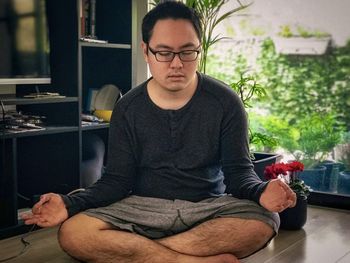 Young man sitting on table at home