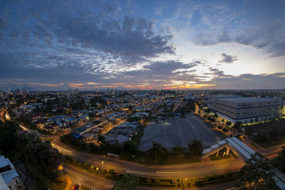 High angle view of illuminated city against sky at sunset