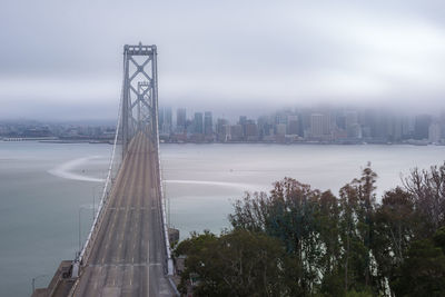 Bridge over river with city in background