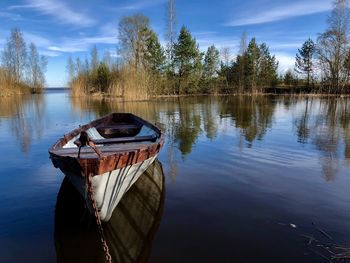 Boat moored in lake against sky