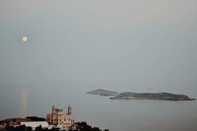 Scenic view of sea and buildings against clear sky