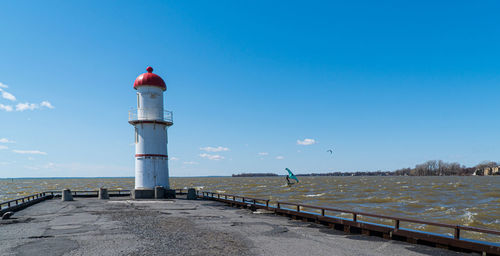 Lighthouse by sea against sky