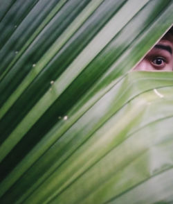 Portrait of a beautiful young woman with green leaf