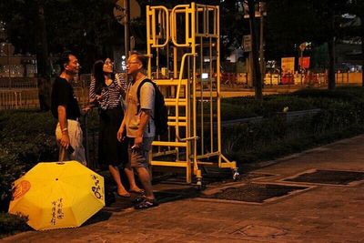 People looking at illuminated city at night