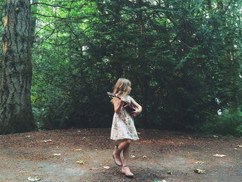 Full length of woman standing in forest