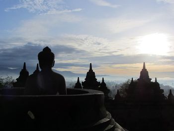 Silhouette statue against sky at sunset