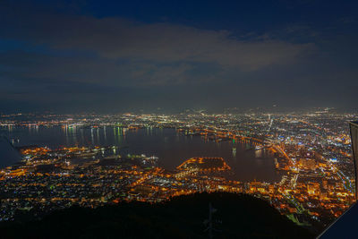 High angle view of illuminated cityscape against sky at night