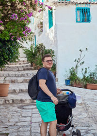 Portrait of young man standing against wall