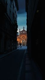 Walkway amidst buildings in city against sky