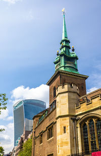 Low angle view of buildings against cloudy sky