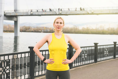 Portrait of woman standing by railing against bridge