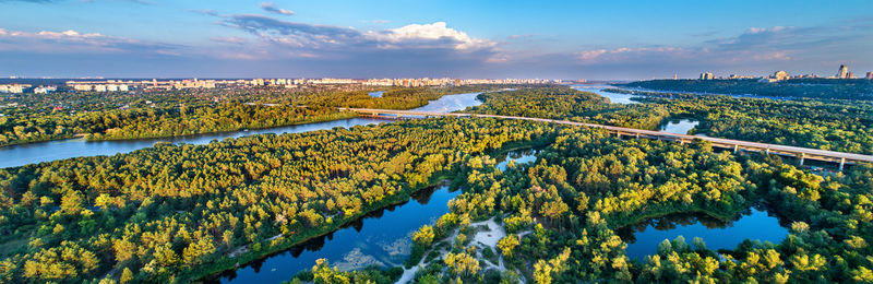 Scenic view of river by trees against sky