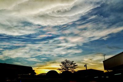 Low angle view of silhouette buildings against sky at sunset