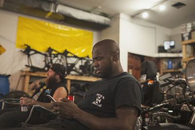 A young man sitting in a workshop.