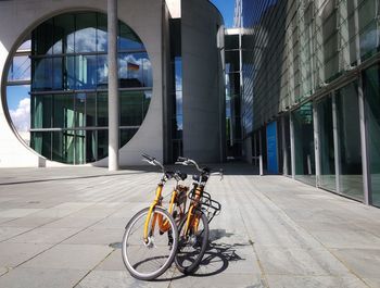 Bicycle on footpath by modern buildings in city