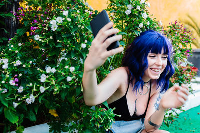 Photo of adorable young woman making selfie outdoors backyard