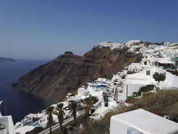 High angle view of buildings by sea against clear sky