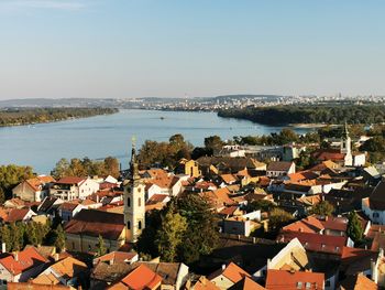 High angle view of townscape by sea against clear sky